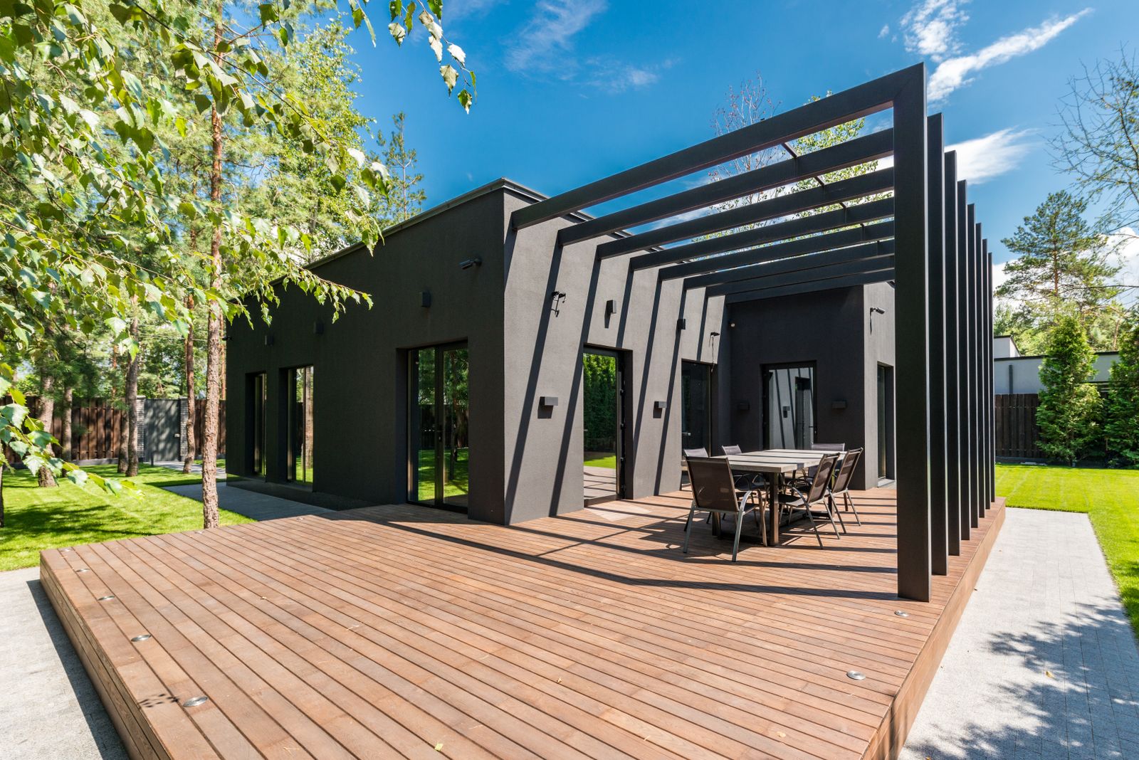 Wooden deck with pergola and outdoor seating in a backyard